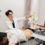 醫師以脊椎模型說明並進行肌肉骨骼超音波檢查